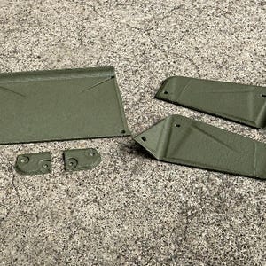 May include: A set of five olive green, textured, rigid components including one large rectangular panel, two elongated angled side pieces, and two small square mounting brackets, all featuring pre-drilled holes for assembly and installation.