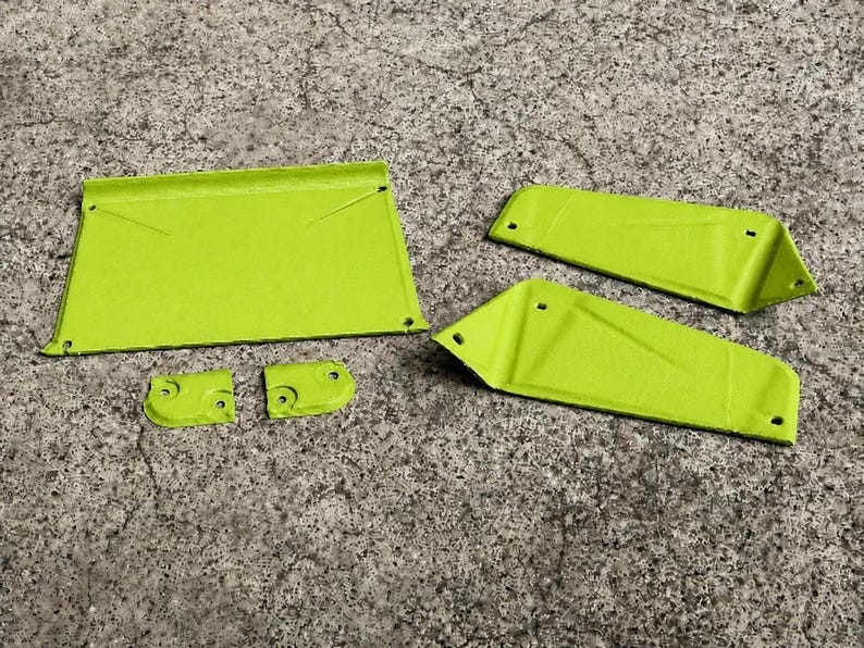 May include: A set of five lime green metal components featuring a flat rectangular piece, two elongated trapezoidal panels, and two small curved brackets. Each piece includes pre-drilled circular holes for assembly and a smooth, matte finish.