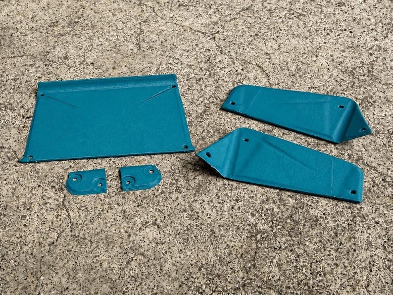 May include: A set of five teal-colored metal components featuring a textured finish. The collection includes one large rectangular panel, two elongated trapezoidal pieces, and two small square-shaped brackets, all with pre-drilled circular holes.