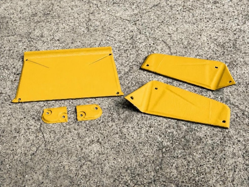 May include: A set of five yellow metal components featuring a large trapezoidal plate, two elongated angled side panels, and two small rectangular brackets, all with pre-drilled holes for assembly and a smooth, uniform painted finish.