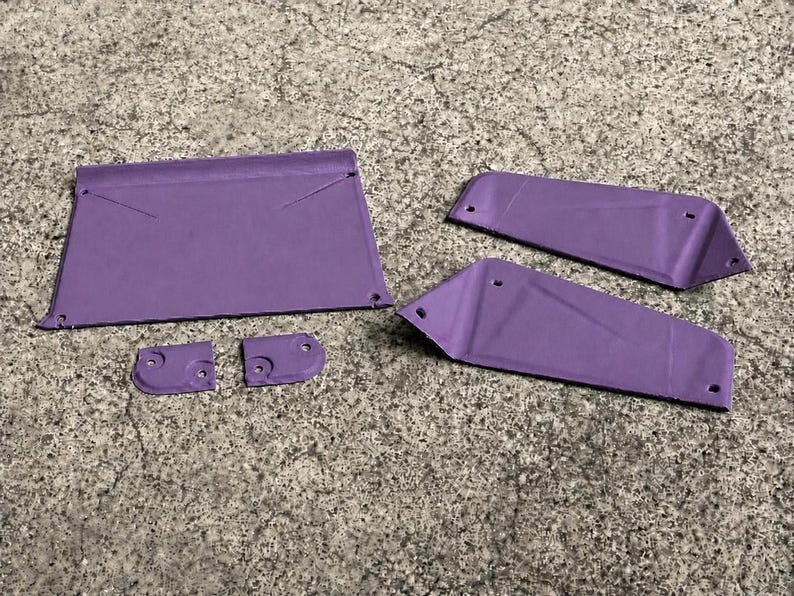 May include: A set of five purple, flat, rigid components with pre-drilled holes. The collection includes one large rectangular piece, two elongated trapezoidal panels, and two small, rounded square connectors, all featuring a matte purple finish.