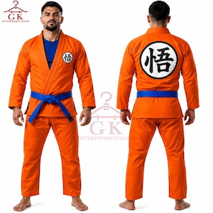 Könnte beinhalten: Ein orangefarbener Kampfkunst-Gi mit blauem Unterhemd und blauem Gürtel. Auf der linken Brust befindet sich ein kleiner weißer Kreis mit einem schwarzen japanischen Schriftzeichen. Der Rücken zeigt einen großen weißen Kreis mit demselben Zeichen.