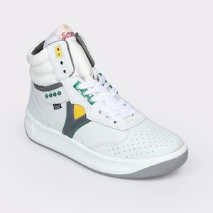 May include: A high-top sneaker in white leather with a perforated toe box, white laces, and a padded collar. The shoe features green, yellow, and grey accents, a small black tag with white text, and a red script logo on the tongue.