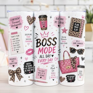 以下が含まれることがあります： 「BOSS MODE ALL DAY EVERY DAY」の文字が入った、モチベーションを高めるデザインの白いタンブラー。デザインには、ヒョウ柄のアクセント、ピンクのハート、インスピレーションを与える引用句が含まれています。タンブラーにはピンクのハンドバッグとサングラスも付いています。