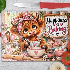 Può includere: Un tagliere rettangolare in vetro con un disegno di una mucca Highland con un fiocco rosa a cuori, che mescola in una ciotola. Il testo recita "Happiness is Baking". Il tagliere è circondato da peperoni, pomodori e un coltello da cucina.