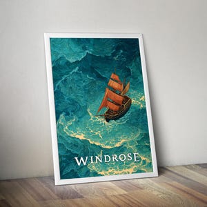 Op de afbeelding: Een ingelijste kunstdruk met een zeilschip met oranje zeilen dat door woelig turquoise water vaart. Het kunstwerk heeft een vintage esthetiek, met het woord "WINDROSE" in het wit gedrukt aan de onderkant. De print wordt gepresenteerd tegen een witte muur en rust op een houten oppervlak.