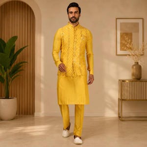 May include: A bright yellow three-piece ensemble consisting of a long-sleeved kurta, matching straight-leg trousers, and a sleeveless vest. The vest features an intricate, repeating geometric pattern with small, reflective metallic embellishments.