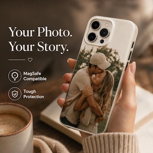 Può includere: Custodia bianca per telefono con una foto di una coppia che si abbraccia, con il testo "Your Photo. Your Story." e icone che indicano la compatibilità MagSafe e una protezione robusta.