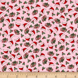 Puede incluir: Tela rosa con un patr&oacute;n repetido de regalos de Navidad rojos y blancos y gorros de Pap&aacute; Noel. El patr&oacute;n est&aacute; sobre un fondo rosa con hojas de acebo verdes.