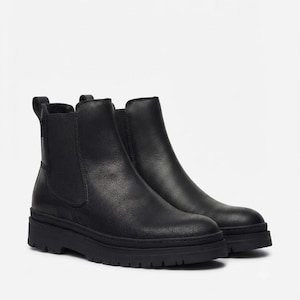 Peut inclure: Une paire de bottines Chelsea en cuir noir avec des panneaux latéraux élastiques, un bout arrondi, une languette au talon et une semelle épaisse en caoutchouc cranté. Les bottines présentent une finition lisse et une silhouette montante.