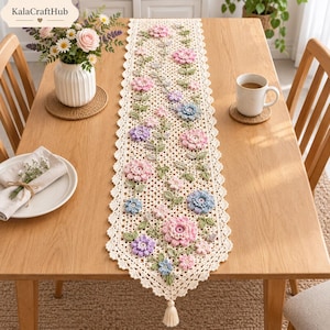 May include: A cream-colored crochet table runner featuring an intricate openwork pattern and a scalloped edge. The runner is decorated with three-dimensional floral motifs in shades of pink, lavender, and light blue, with green leaves and a tassel.