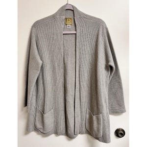 May include: A gray ribbed cardigan with a long, open front and two pockets. The cardigan has a D for Draper label on the front.