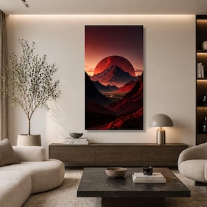 Op de afbeelding: Een verticale wandkunstprint met een dramatisch landschap met een grote, dieprode zon die ondergaat achter grillige, donkere bergtoppen. De scène toont een vallei met diepe schaduwen en levendige karmozijnrode tinten voor een contrastrijk beeld.