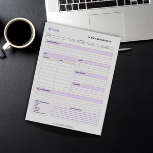 May include: A script breakdown sheet with a purple and white design, featuring sections for scene description, cast, props, and production notes. The sheet is on a black surface next to a laptop and a cup of coffee.