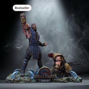 以下が含まれることがあります： Mortal Kombatのシーンを描いた詳細な像。青と黒の衣装のキャラクターが切断された頭を持ち上げています。別のキャラクターが近くにひざまずいています。ベースにはゲームのロゴと「Spine Rip」のテキストが表示されています。