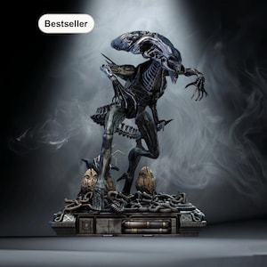 Könnte beinhalten: Detaillierte Statue eines Alien Xenomorph-Kreatur, mit einem Skelett-Design und einem länglichen Kopf. Die Figur ist dunkelgrau und schwarz, auf einem Sockel mit mechanischen Details und zwei Alien-Eiern. Das Wort "Bestseller" steht in einem weißen Oval.