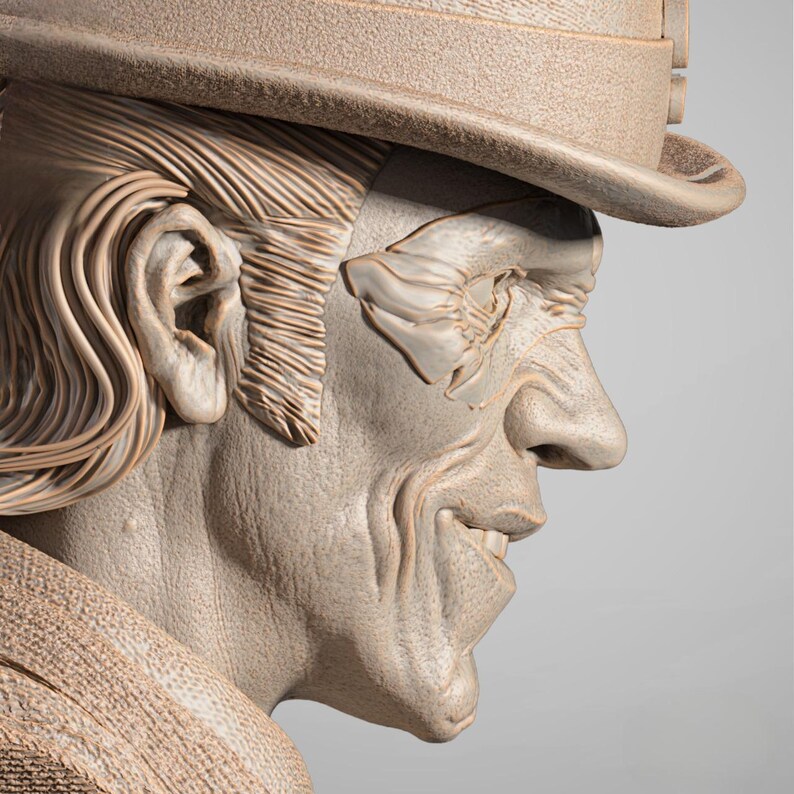 May include: A detailed sculpture of a man's face in profile, wearing a hat. The sculpture is a neutral beige color, with visible textures and lines that emphasize the facial features, including the hair, ear, and hat.
