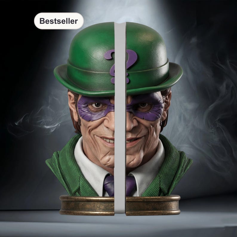 May include: The Riddler bust bookends. The bust features a green bowler hat with a purple question mark, a purple mask, and a green suit. The bookends are made of a bronze-colored material and are split down the middle.