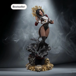 Puede incluir: Estatua detallada de una maga con un atuendo rojo y negro, sosteniendo naipes. La estatua presenta un halo dorado, medias de rejilla y está colocada sobre una base con calaveras y un sombrero de copa. La palabra "Bestseller" está en un óvalo blanco en la esquina superior izquierda.