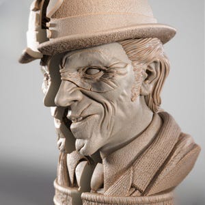 May include: A detailed bust sculpture of a man wearing a fedora hat and a suit jacket. The sculpture is a light beige color, with intricate details on the face, hair, and clothing. The man has a stern expression.