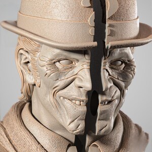 May include: A detailed bust of a character with a split face, wearing a fedora hat. The bust is a neutral beige color, with intricate details on the face and clothing. The split reveals a dark, contrasting interior.