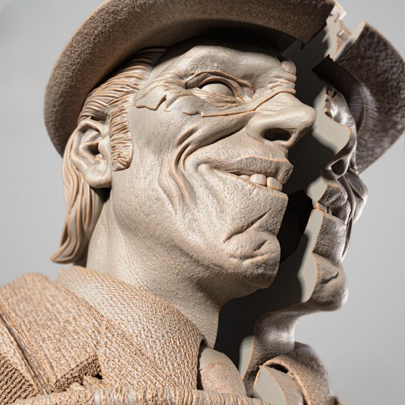 May include: A detailed sculpture of a smiling face wearing a hat. The sculpture is a light beige color, with visible textures and lines. The face is split, revealing a second face behind it. The hat is a similar color and style.