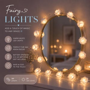 May include: A string of 20 warm white LED fairy lights shaped like roses, measuring 3 metres in length. The lights are battery operated, requiring 3 AA batteries, and are draped around an oval mirror with a gold frame on a table surface.