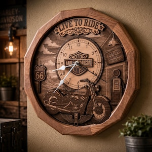 Op de afbeelding: Een ronde houten wandklok met een Harley-Davidson motorfietsafbeelding, de tekst LIVE TO RIDE, een Route 66-bord en een vintage benzinepomp. De wijzerplaat heeft zwarte cijfers en witte wijzers in een achthoekig houten frame.