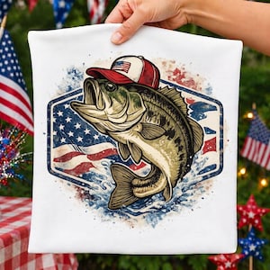 May include: White pillowcase featuring a graphic of a largemouth bass wearing a red, white, and blue baseball cap. The fish is set against a backdrop of the American flag within a blue hexagonal frame, with water splashes.
