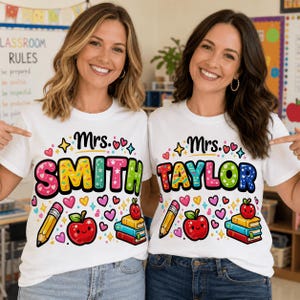 May include: Two white t-shirts with the names "Mrs. Smith" and "Mrs. Taylor" in colorful, playful lettering. Each shirt features a pencil, a red apple, books, and hearts. The shirts are worn by two smiling women.