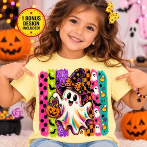 May include: A pale yellow t-shirt featuring a graphic of a white ghost wearing a witch hat and holding a jack-o'-lantern bucket. The design includes vertical stripes with patterns of bats, spiderwebs, ghosts, and candy corn. Text reads 1 BONUS DESIGN INCLUDED!