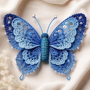 May include: A crochet butterfly ornament featuring intricate lace-like wings in shades of dark blue and light blue. The central body is a solid dark blue cylinder, and the wing edges are adorned with small white beads and two antennae with beads.