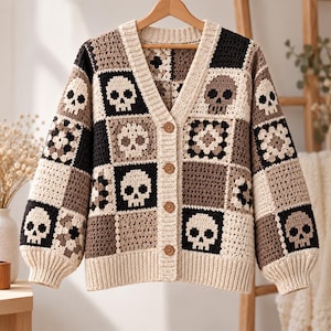Puede incluir: Un cárdigan de ganchillo de manga larga con un diseño de patchwork de cuadrados alternos en crema, marrón y negro. El patrón incluye motivos de calaveras y cuadrados de ganchillo florales. Tiene cuello en V, dobladillo acanalado y cuatro botones marrones.