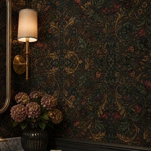 May include: A bathroom vanity area featuring dark floral wallpaper, a white marble countertop with a brass faucet, a ribbed glass vase with dried hydrangea flowers, a brass soap dish with a bar of soap, and a brass wall sconce with a beige shade.