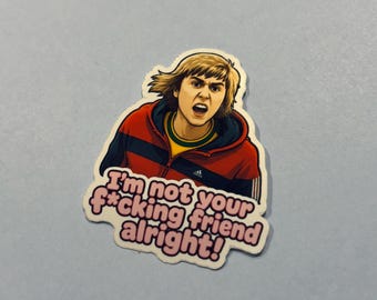 May include: A sticker featuring a cartoon illustration of a person with blonde hair wearing a red and black jacket. The sticker has the text "I'm not your f*cking friend alright!" in a pink font.