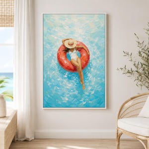 May include: An oil painting on canvas depicting a person wearing a white swimsuit and a straw hat, floating in a bright red circular pool float. The background consists of textured, thick brushstrokes in shades of light blue and turquoise water.