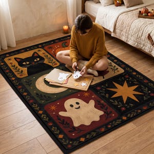 May include: A rectangular area rug featuring a grid of seasonal illustrations including a black cat, a smiling ghost, a large yellow star, and a pumpkin. The design incorporates autumn-themed foliage, stars, and a crescent moon in a palette of black, orange, red, and cream.