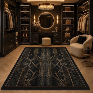 Könnte beinhalten: Ein rechteckiger Teppich mit einem geometrischen Muster in Dunkelblau und Gold, das symmetrische Linien und fächerartige Motive aufweist. Der Teppich liegt auf einem hellen Holzboden in einem Raum mit dunklen Schränken und einem beigen Sessel.