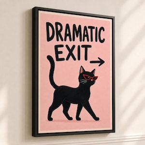 May include: A framed wall art print featuring a black cat wearing red cat-eye glasses on a light pink background. The text DRAMATIC EXIT is printed in black above the cat, accompanied by a black arrow pointing to the right side of the frame.