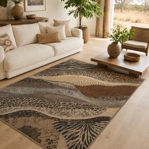 May include: A rectangular area rug featuring a layered, abstract pattern with wavy bands of animal print motifs, including leopard spots and zebra stripes, in a neutral color palette of beige, tan, dark brown, gray, and black on a light floor.