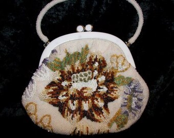 May include: A white beaded evening bag with a floral design. The bag has a white clasp and a beaded strap.