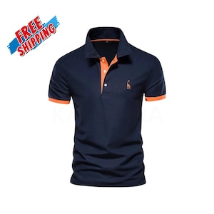 May include: A navy blue short-sleeved polo shirt featuring a contrasting orange inner placket and sleeve cuffs. The shirt has a three-button closure and an embroidered orange giraffe logo on the left chest area, providing a distinct color accent.