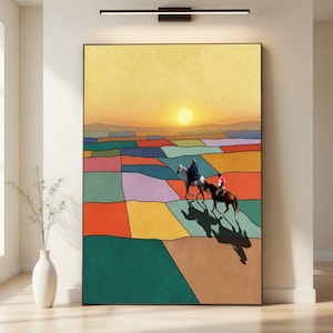 May include: A framed art print showing a sunset over a colourful patchwork landscape. Two figures on horseback are silhouetted against the setting sun. The artwork features a vibrant palette of colours, including orange, yellow, green, and purple.