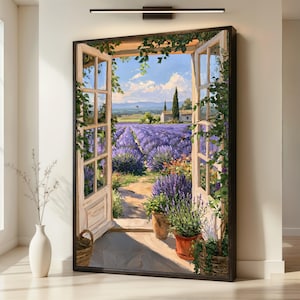 May include: A framed wall art print depicting an open window view of a sprawling lavender field under a blue sky. The scene features white wooden window frames, climbing green vines, potted plants on a stone floor, and a distant farmhouse.