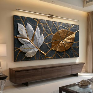 May include: A large rectangular wall art piece featuring a dark textured background with a white marble-like leaf on the left and a metallic gold leaf on the right, both accented by thin gold lines resembling veins across the dark surface.