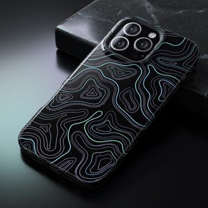 May include: A black smartphone case featuring a glossy finish and a white and light blue topographic map line pattern. The case includes a square camera cutout with three circular lenses visible on the back of the device, showcasing a sleek design.