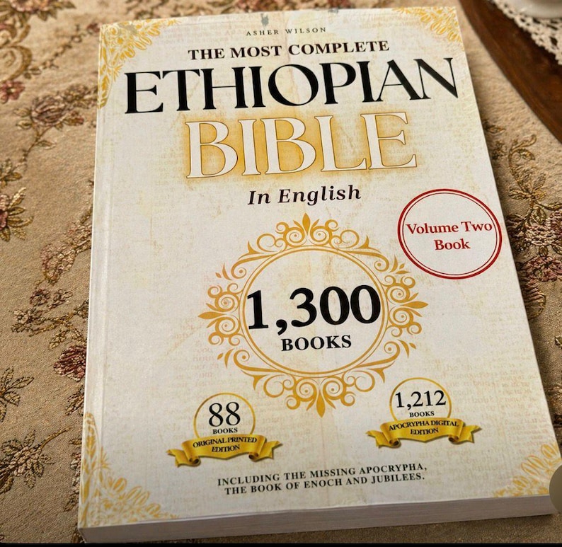 May include: The Most Complete Ethiopian Bible, Volume Two, in English. The book cover is cream-colored with gold accents and text. It features the text "1,300 BOOKS" in a gold circle, and includes the missing Apocrypha.