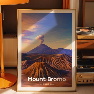 Può includere: Una stampa artistica da parete verticale incorniciata con un'illustrazione paesaggistica del Monte Bromo in Indonesia. L'immagine mostra un vulcano fumante, un terreno marrone accidentato e un cielo blu. Il testo Mount Bromo e INDONESIA è in basso.