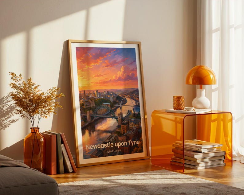A vibrant Newcastle upon Tyne artwork rendered in high-detail illustrative style, placing the Tyne Bridge at the heart of the composition with the Millennium Bridge and warm Victorian quayside terraces rising beside the River Tyne in rich layered tones. Bold white NEWCASTLE typography sits beneath drifting illustrated clouds. Gold frame leaning against a cream wall on parquet flooring, paired with an amber glass vase, stacked books, and an amber side table with an orange dome lamp.