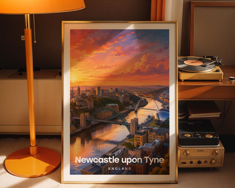 Designed as a Newcastle upon Tyne art print, this high-detail illustrated cityscape places the Tyne Bridge and Millennium Bridge at centre stage above the River Tyne, with the quayside's stacked Victorian facades rendered in warm layered colour and bold white NEWCASTLE typography. Gold frame leaning against a dark taupe wall beside a tall floor lamp with an orange shade, a vintage record player, stacked vinyl, and terracotta curtains.